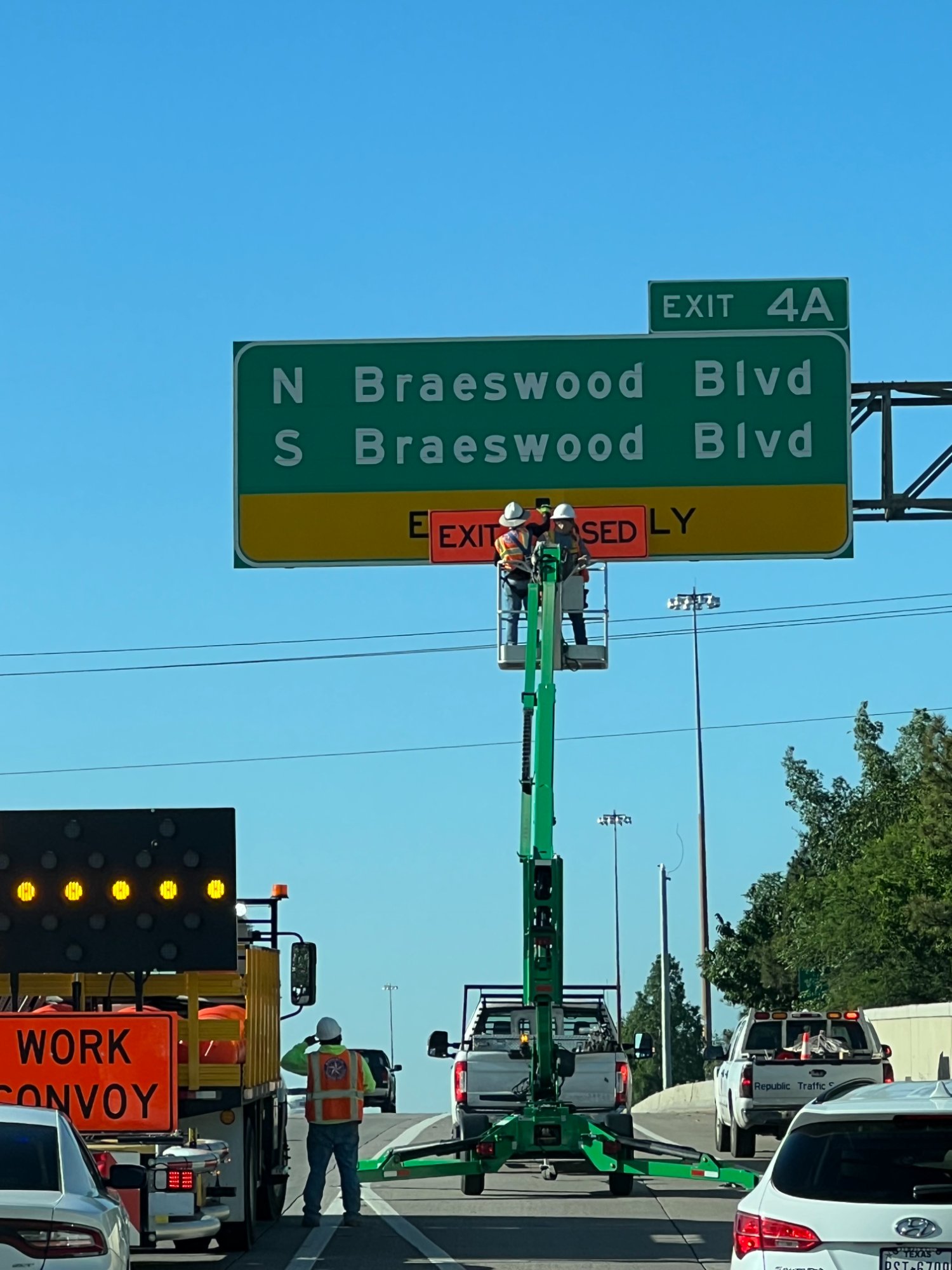 Republic Traffic Safety crew on boom lift installing highway sign at Braeswood Blvd Houston TxDOT